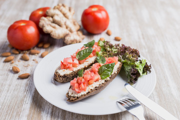 Two bruschettas, ginger and tomatoes