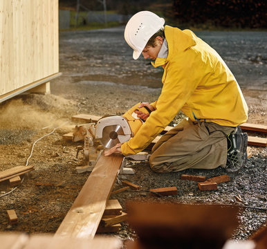 Man sawing decking board with circular saw