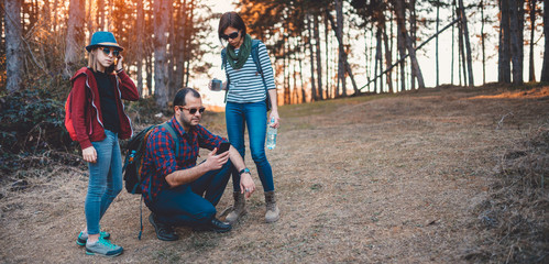 Family hiking in the forest and using smart phone