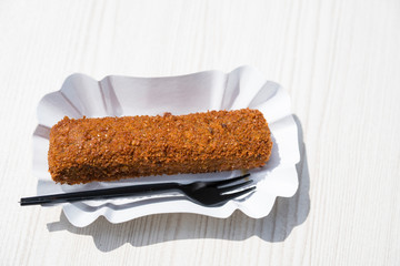 close up Dutch fried snack croquet, on white paper bowl with plastic fork