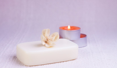 Fototapeta na wymiar NATURAL SOAP WITH PERFUMED DRY FLOWER AND CANDLES IN THE BACKGROUND