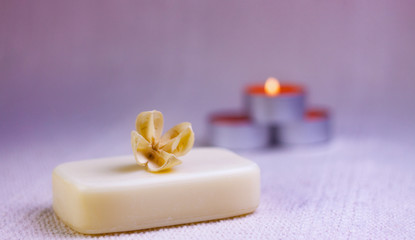 Fototapeta na wymiar NATURAL SOAP WITH PERFUMED DRY FLOWER AND CANDLES IN THE FUND