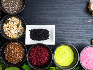 Super food health food selection in bowls, spirulina, berry powder, black cumin, pumpkin and sunflower seeds, sesame, flex seeds, pomegranate powder
