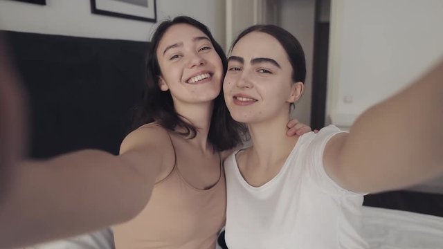 Happy lesbian couple taking selfie photo at home. People, romantic relationship concept. Slow motion.