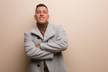 Young latin business man smiling confident and crossing arms, looking up