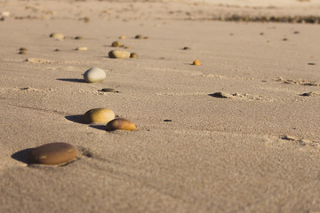 Colorful pebbles on sand. Round stones on the beach. Peaceful concept. Nature details. Coast nature. Ocean pebbles with unfocused background.