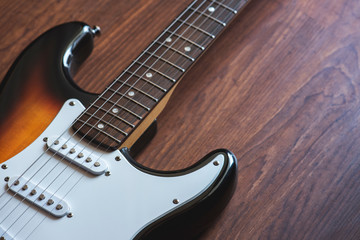 Electric guitar on the wooden background.