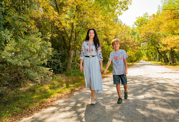 Obraz premium happy mother and son on the background of autumn trees