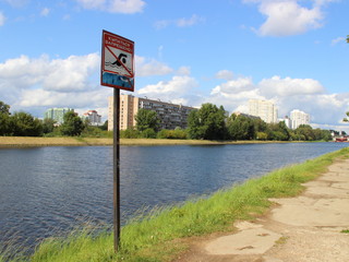 Moscow / Russia – 08 26 2017:  Navigation canal name of Moscow in Tushino before the crash - view to Russian inscription 'no swim' near water and sluice #7