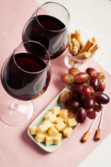 Two glasses of red wine with snacks