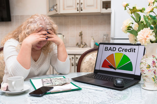 Woman in the age of housewife calculates his finances and analyzes the credit history, compiles a credit report on a computer. Credit score. Laptop. Technology.