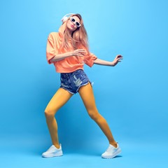 Young positive hipster Woman dance Having Fun, stylish fashion headphones. Beautiful excited...