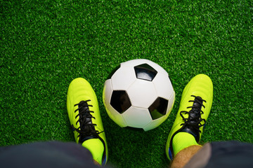 Fototapeta na wymiar Soccer shoes and football on the green grass