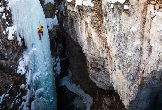 Alpine climber Jess Roskelley climbing the 45 meter/148-foot Tokumm Pole above the Tokumm Creek in the scenic Marble Canyon, BC in Kootenay National Park near Banff, Alberta. The rugged, narrow slot canyon is a popular summer destination with the turquoise waters of Tokumm Creek flowing at the bottom. But in the winter it is a hotspot for ice climbing, snowshoeing, and nordic skiing.
