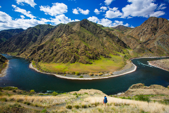 A female backpacker on the scenic Snake River National Recreation Trail (#102) in Hells Canyon along the Oregon-Idaho border. The canyon is the deepest river gorge in North America with more than a mile of vertical elevation between the river floor and nearby peaks in the Seven Devil Mountains.