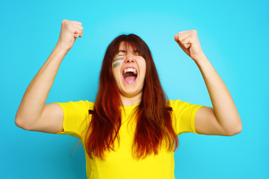 Woman is socccer fan in yellow t-shirt
