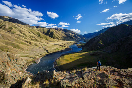A female backpacker at the 400-foot Suicide Point along the scenic Snake River National Recreation Trail (#102) in Hells Canyon along the Oregon-Idaho border. The canyon is the deepest river gorge in North America with more than a mile of vertical elevation between the river floor and nearby peaks in the Seven Devil Mountains.