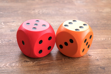 yellow and red cubes for dice, a wooden background, close-up