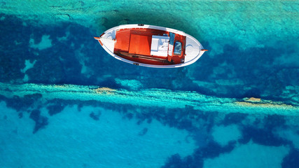 Aerial drone top view photo of red wooden traditional fishing boat in turquoise sea shore of Zakynthos island, Ionian, Greece