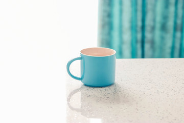 Close up blue cup on a white table on a White and Blue background