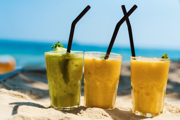 Exotic summer cocktails, shaked mix drinks and blur sandy beach on background as symbol of vacation holidays at the sea