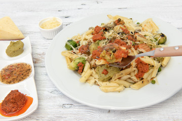 Pasta de macarrones con salsa roja, amarilla y verde.