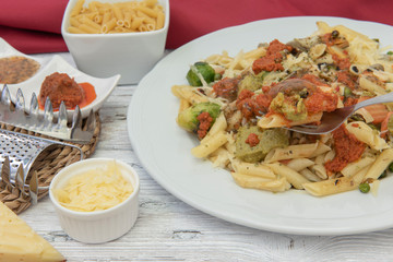 Pasta de macarrones con salsa roja, amarilla y verde.