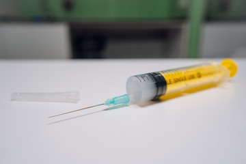 One one-off yellow medical syringe with needle lying