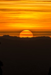 Fototapeta na wymiar Panorama al tramonto con cielo pennellato e silhouette del paesaggio