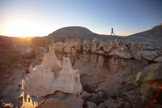 A woman goes for a run at the remote Fantasy Canyon, Utah during a quick stop to explore the delicate, otherworldy sandstone formations at this small-but-fascinating 10-acre preserve at sunset.