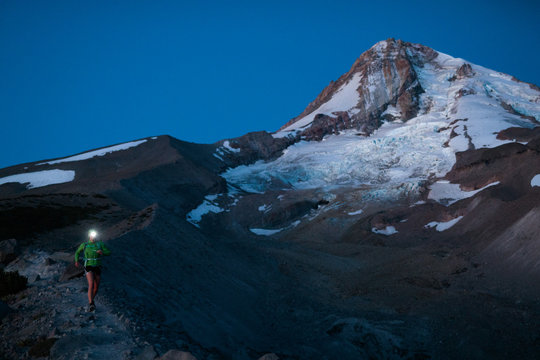 A female trail runner goes for a predawn run along the scenic climber's trail cresting the glacial moraine from the receding Elliot Glacier near the base of the Cooper Spur on Mount Hood, Oregon.