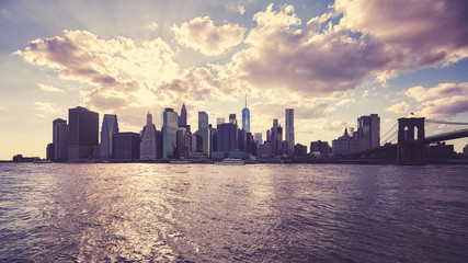 Manhattan skyline silhouette at sunset, color toning applied, NYC.