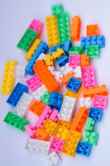 Fototapeta na wymiar Multicoloured plastic construction blocks or bricks toy on white background