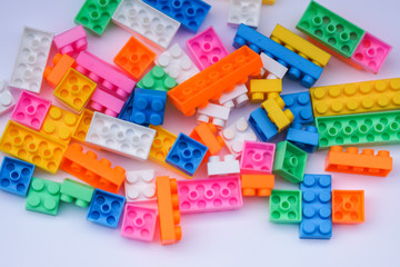 Multicoloured plastic construction blocks or bricks toy on white background