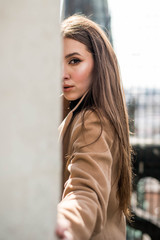 Obraz premium Young beautiful woman with long brown hair in sunglasses on a walk on a cloudy day. Fashionable sexy girl. Street fashion look. Cute student.