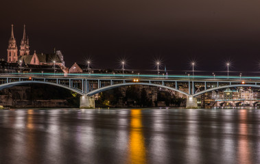 Obraz premium Tram running over Wettsteinbrucke bridge on long exposure with reflection in the Rhein river and night city lights