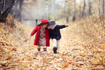 boy and girl in hats walk in park, autumn mood