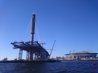Fototapeta na wymiar Construction of the bridge in St. Petersburg, a clear day, the view from the water.