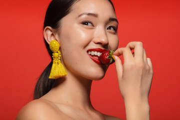 Pretty woman eating fresh strawberry