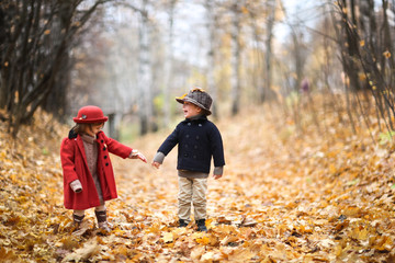 boy and girl in hats walk in park, autumn mood