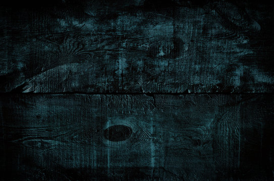 Black tinted wood texture, top view of dark wooden table. Colored blue rustic wall background, texture of old top table, grunge gloomy background