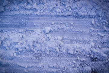 tracks of vehicle tyres in white snow with vignette. background, seasoned.