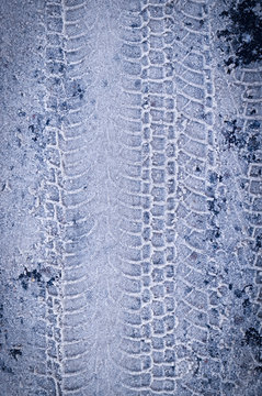 tracks of vehicle tyres in white snow with vignette. background, seasoned.