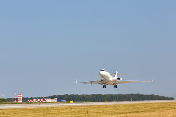 White plane takes off. Blue sky. Free space. Flight over the field and the airport. - 262094321