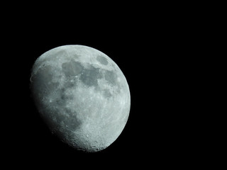 a close-up of a three-quarter moon in the night sky