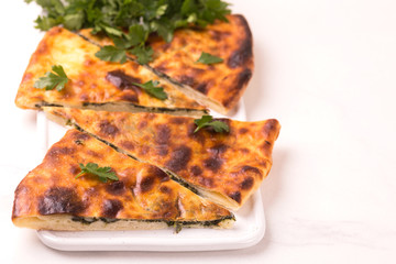 Khachapuri Megrelian with spinach and parsley. Pita bread with cheese