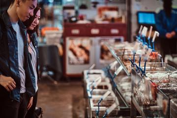 Asian couple looking for something special at market.