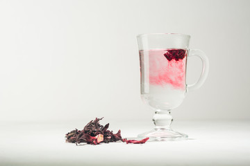 Transparent glass Cup with hot red tea from hibiscus or hibiscus.