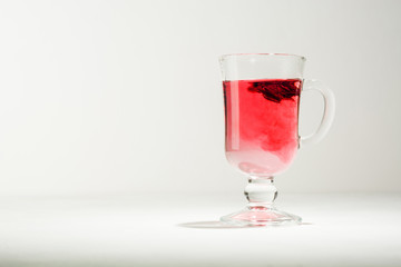 Transparent glass Cup with hot red tea from hibiscus or hibiscus.