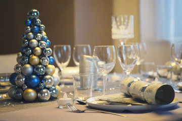 Family dinner table for Christmas with baubles tree.